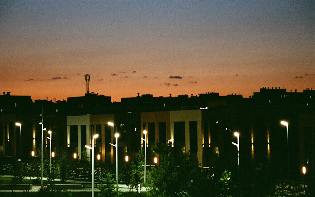 City skyline at dusk with buildings and street lights