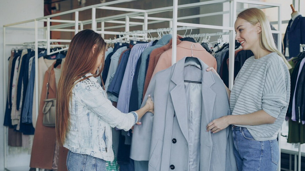 woman trying on coat in store