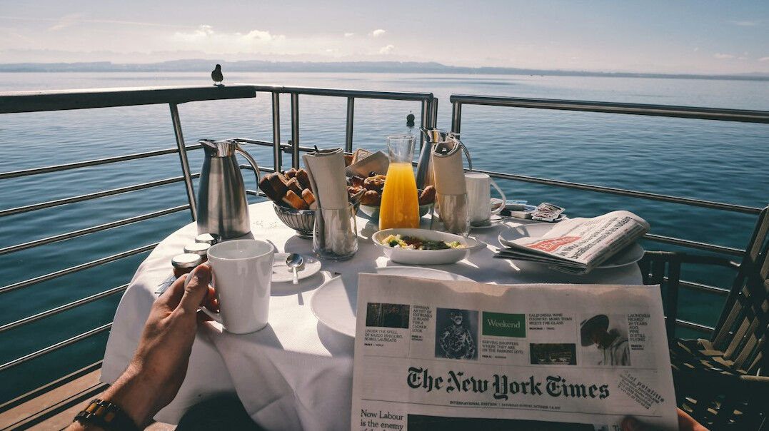 Newspaper pages being read at a table